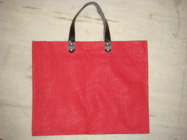 RED DYED JUTE BAG WITH REXINE HANDLE  .
