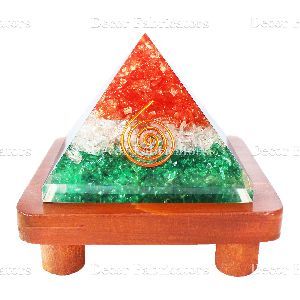Orgone Tricolor Vastu Pyramid with Round Spring Symbol On a Brown Wooden Stand