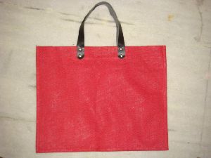 RED DYED JUTE BAG WITH REXINE HANDLE  .
