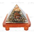Orgone Labradorite Stone Vastu Pyramid with Round Spring Symbol On a Brown Wooden Stand