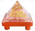 Rose Stone Orgone Vastu Pyramid with Golden Happy Birthday Symbol On a Brown Wooden Stand